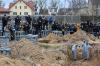 SERGEI SUPINSKY - AFP via GETTY IMAGES
Journalists gather as bodies are exhumed from a mass grave in the grounds of the St. Andrew and Pyervozvannoho All Saints church in the Ukrainian town of Bucha, northwest of Kyiv on April 13, 2022.