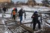 Marcus Yam - TNS
Volunteer fighters transport rifles across a river under a destroyed bridge to reinforce Ukrainian troops in Irpin, Ukraine, on Tuesday.
