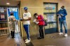 People who were just tested for COVID-19 wait in line to make payment for the test at a private laboratory in Johannesburg, South Africa, Saturday Dec. 19, 2020. South Africa is bracing for its second wave, as many people will travel across provinces for vacations and visiting their families. (AP Photo/Jerome Delay)