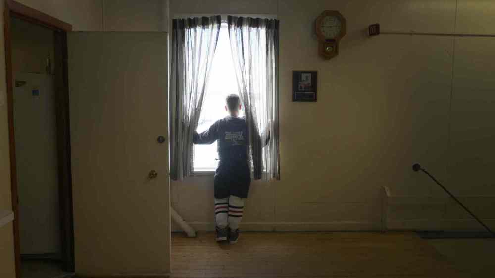 JOE BRYKSA / WINNIPEG FREE PRESS A player looks out the window between games in Foxwarren, Manitoba.