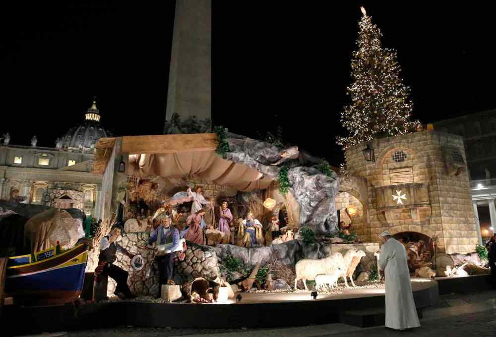 Pope Francis prays in front of a nativity scene in St. Peter's Square, after celebrating a new year's eve vespers Mass in St. Peter's Basilica at the Vatican, Saturday, Dec. 31, 2016. (Alessandro Bianchi/Reuters pool via AP)
