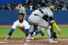 Toronto Blue Jays left fielder Raimel Tapia slides safely into home ahead of a tag by Chicago White Sox catcher Yasmani Grandal, right, on a double by Jays&nbsp;second baseman Santiago Espinal during fifth inning American League baseball action in Toronto on Thursday, June 2, 2022. THE CANADIAN PRESS/Jon Blacker