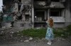 A woman takes pictures of a building destroyed by shelling, in Borodyanka, on the outskirts of Kyiv, Ukraine, Saturday, June 4, 2022. (AP Photo/Natacha Pisarenko)
