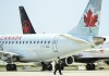 Airline ground crew walks past grounded Air Canada planes as they sit on the tarmac at Pearson International Airport, in Toronto on Tuesday, April 27, 2021. Half a million passengers sat aboard delayed international flights at Pearson in May. THE CANADIAN PRESS/Nathan Denette