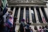 A tour group stops in front of the New York Stock Exchange in New York, Tuesday, June 14, 2022. Wall Street is wobbling between gains and losses Tuesday in its first trading after tumbling into a bear market on worries about a fragile economy and rising rates. (AP Photo/Seth Wenig)