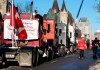 A person wears a Team Canada hockey jersey as Wellington Street is lined with trucks once again after city officials negotiated to move some trucks towards Parliament and away from downtown residences, on the 18th day of a protest against COVID-19 measures that has grown into a broader anti-government protest, in Ottawa, on Monday, Feb. 14, 2022. THE CANADIAN PRESS/Justin Tang