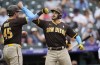 San Diego Padres' Luke Voit, left, congratulates Austin Nola who crosses home plate after hitting a two-run home run off Colorado Rockies relief pitcher Robert Stephenson in the eighth inning of a baseball game Sunday, June 19, 2022, in Denver. (AP Photo/David Zalubowski)