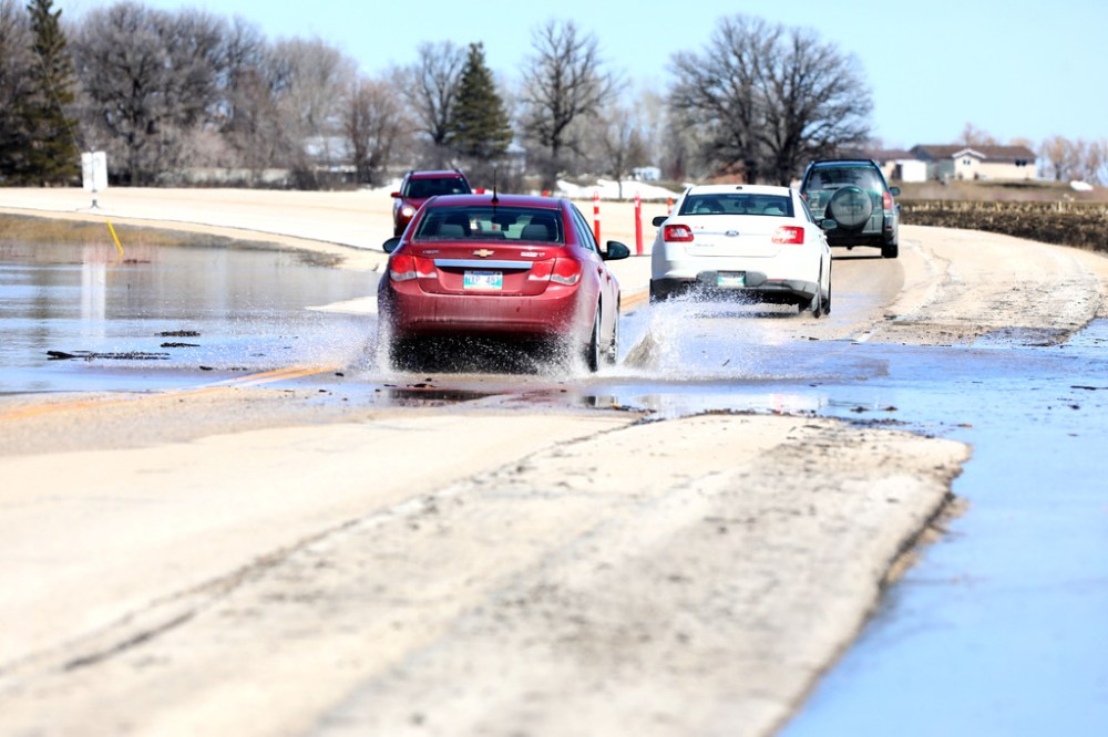 PR 200, north of  St. Adolfe, with water from the Red River spilling across the roadway slowing traffic down to one lane. (Ruth Bonneville / Winnipeg Free Press)
