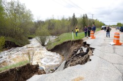 Transportation and Infrastructure Minister Doyle Piwniuk, Agriculture Minister Derek Johnson, and Sarah Thiele, deputy minister, Manitoba Transportation and Infrastructure along with other government employees walk along Provincial Road 222 near Lakeside Road where it has been mostly washed out just north of Gimli, MB, as part of a provincial tour of flooded areas, June 02, 2022. (Mike Deal / Winnipeg Free Press)