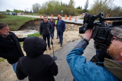 Transportation and Infrastructure Minister Doyle Piwniuk (left), Agriculture Minister Derek Johnson (right), and Sarah Thiele (centre), deputy minister, Manitoba Transportation and Infrastructure talk to reporters along Provincial Road 222 near Lakeside Road where it has been mostly washed out just north of Gimli, MB, as part of a provincial tour of flooded areas, June 2, 2022. (Mike Deal / Winnipeg Free Press)