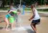 Owen, 8, (in green) and his sister Aubree, 5, (in pink) try to beat the heat by playing at the splash pad at Fort Rouge Park Sunday. Temperatures reached 37 C. (Jessica Lee / Winnipeg Free Press)