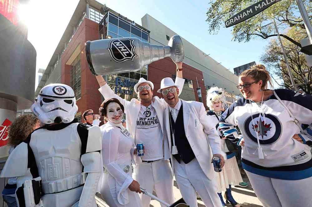 RUTH BONNEVILLE / WINNIPEG FREE PRESS
Brandon Klimenko (with friend Jeff Pinchin — both wearing white hats) hoists a fake Stanley Cup on Donald Street at Graham Avenue during the Whiteout street party before the start of Game 1 of the Western Conference final between the Winnipeg Jets and the Las Vegas Golden Knights in Winnipeg, Saturday, May 12, 2018. Klimenko hopes the Jets will win the real one.