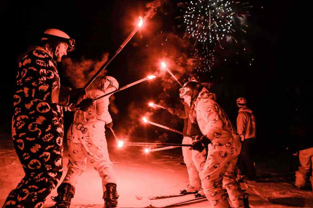 Vail ski and snowboard instructors, some dressed up, help celebrate the New Year after the Torchlight Parade  on Golden Peak, Saturday, Dec. 31, 2016, in Vail, Colo. More than 200 instructors and hundreds of Beavo ski school students participated, which followed with fireworks. (Chris Dillmann/Vail Daily via AP)