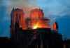 Firefighters tackle the blaze as flames and smoke rise from Notre Dame cathedral as it burns.  (Michel Euler / The Associated Press)