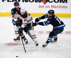 Nikolaj Ehlers and Pierre-Luc Dubois check Ryan Nugent-Hopkins during the first period. (Fred Greenslade / The Canadian Press)