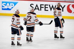 Edmonton Oilers’ Connor McDavid watches the replay following a Winnipeg Jets goal with teammates Tyson Barrie and Darnell Nurse during the first period. (Fred Greenslade / The Canadian Press)