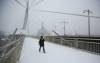 Daryl Kuhl crosses the Esplanade Riel Footbridge Wednesday morning despite the blowing snow. (Mike Deal / Winnipeg Free Press)