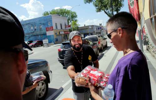 Early childhood education assistant Justin Kalinouski gives out food items.