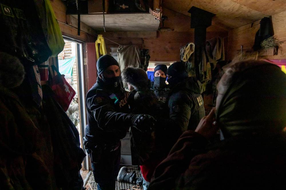 Amber Bracken photo
Militarized police, after breaching the door with an axe and chainsaw, move in to arrest Sleydo’ and supporters at Coyote Camp on Nov. 19.