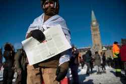 A person holds a copy of the Canadian Charter of Rights and Freedoms during a rally against COVID-19 restrictions on Parliament Hill. (Justin Tang / The Canadian Press)