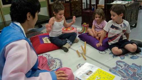 Danielle Da Silva - Sou'wester
Elizabeth, 6, Caroline, 3, and James Curran, 5, play a game of Yut-Nori in the Korean cultural display.