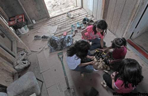 JOE.BRYKSA@FREEPRESS.MB.CA
Kids play in a Garden Hill porch near a slop pail used as a toilet.