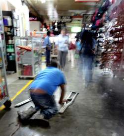 A badly crippled man makes his way on hands and knees through a Managua public market. Winnipeg