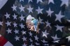 Abortion rights activists are seen through a hole in an American flag as they protest outside the Supreme Court in Washington, Saturday, June 25, 2022. The Supreme Court’s decision to overturn national protections for abortion has set off a contest between Democratic and Republican lawmakers over whose policies would do more to help vulnerable mothers and children. It's a key issue going into the midterm elections. (AP Photo/Jose Luis Magana)