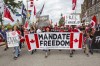 People protest and march on Wellington street against COVID-19 health measures during Canada Day in Ottawa, Ontario, on Friday July 1, 2022. THE CANADIAN PRESS/Lars Hagberg