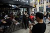 People use electronics outside a coffee shop in Toronto amid a countrywide Rogers outage, affecting many of the telecommunication company's services, Friday, July 8, 2022. THE CANADIAN PRESS/Cole Burston