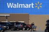 FILE - A woman wheels a cart with her purchases out of a Walmart, on Nov. 18, 2020, in Derry, N.H. Walmart, the nation’s largest employer, is expanding its abortion coverage for employees, according to a memo sent to employees Friday, Aug. 19, 2022, after staying mum on the topic for months following the Supreme Court ruling that scrapped a nationwide right to abortion. (AP Photo/Charles Krupa, File)