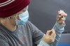 Clinic volunteer Kelly Brown draws out Moderna vaccine during a drive through COVID-19 vaccine clinic at St. Lawrence College in Kingston, Ont., on January 2, 2022. THE CANADIAN PRESS/Lars Hagberg