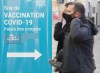 People walk by a COVID-19 vaccination sign at a vaccination site in Montreal on Jan. 8, 2022. Quebec health officials say they are expecting to offer the new COVID-19 bivalent vaccine in less than two weeks. THE CANADIAN PRESS/Graham Hughes