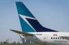 THE CANADIAN PRESS FILES/Jeff McIntosh
                                The tail of a WestJet plane is seen dwarfing the Calgary skyline before the airline’s annual meeting in Calgary, Tuesday, May 3, 2016. The Transportation Safety Board says an onboard fire that forced a WestJet plane to return to the Calgary International Airport soon after takeoff last June was caused by spare e-cigarette lithium-ion batteries that a passenger failed to declare in his checked baggage.