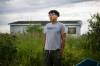 Dysin Spence stands for a photo outside of the now condemned home where he grew up in Peguis First Nation, Manitoba on July 11, 2022. Aaron Vincent Elkaim for The Narwhal