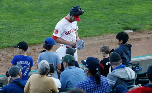 JOHN WOODS / WINNIPEG FREE PRESS
                                Landen Bourassa signs autographs for some children as Goldeyes and fans wait for a game delay to end before the teams hit the field Monday.