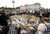 Long lines of mourners form and lay flowers as people wait to pay their respects at the gates of Buckingham Palace in London, Saturday, Sept. 10, 2022. Queen Elizabeth II, Britain's longest-reigning monarch and a rock of stability across much of a turbulent century, died Thursday Sept. 8, 2022, after 70 years on the throne. She was 96. THE CANADIAN PRESS/Nathan Denette