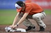 A member of the ground crew cleans a 9/11 remembrance base between innings of the Baltimore Orioles and the Boston Red Sox baseball game, Sunday, Sept. 11, 2022, in Baltimore. (AP Photo/Gail Burton)