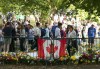 Long lines of mourners lay flowers near a Canadian flag as people wait to pay their respects to Queen Elizabeth II near the gates of Buckingham Palace in London on Sunday, Sept. 11, 2022. The British Columbia government says it will follow the federal government's lead and honour the national day of mourning to mark the funeral for the Queen. THE CANADIAN PRESS/Nathan Denette