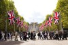 People walk across The Mall in front of the Victoria monument and Buckingham Palace as visitors from all over the world arrive to pay their respects to the Queen in London, Friday, Sept. 16, 2022. Alberta Premier Jason Kenney says he joined a queue with hundreds of thousands of people to pay his respects to Queen Elizabeth, whose coffin is to lie in state until her funeral. THE CANADIAN PRESS/Nathan Denette