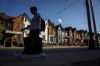 A person walks by a row of houses in Toronto on Tuesday July 12, 2022. Statistics Canada will release its latest 2021 census report on the housing landscape in Canada this morning.THE CANADIAN PRESS/Cole Burston