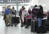 People wait in line to check in at Pearson International Airport in Toronto on Thursday, May 12, 2022. The federal Liberal cabinet is considering whether to renew COVID-19 vaccine mandates and mandatory random testing. THE CANADIAN PRESS/Nathan Denette