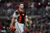 FILE - San Francisco Giants catcher Buster Posey walks on the field during the team's baseball game against the Atlanta Braves on Aug. 27, 2021, in Atlanta. The Giants announced Wednesday, Sept. 21, 2022, that the 35-year-old former catcher has joined the ownership group. Posey, while not announcing the percentage, said he bought in with his own money. He's also joining the six-person board of directors. (AP Photo/John Bazemore, File)