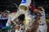 Philadelphia Phillies' Matt Vierling is doused by teammates after he hit a game-winning RBI-single against Toronto Blue Jays pitcher Adam Cimber during the 10th inning of a baseball game, Wednesday, Sept. 21, 2022, in Philadelphia. (AP Photo/Matt Slocum)