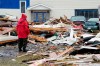 A Canadian Forces Ranger examines damage to a home in Port aux Basques, N.L., Monday, Sept. 26, 2022. Across the Maritimes, eastern Quebec and in southwestern Newfoundland, the economic impact of post-tropical storm Fiona’s wrath is still being tallied. THE CANADIAN PRESS/Frank Gunn