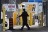 A border officer walks past security cameras at the Thousand Islands border, near Gananqoue, Ont., Monday, March 16, 2020.&nbsp;The federal privacy watchdog says a data breach at a contractor for Canada's border agency involved as many as 1.38 million licence plate images. THE CANADIAN PRESS/Lars Hagberg