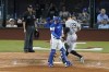 Texas Rangers catcher Kevin Plawecki and umpire Gabe Morales stand near the plate as New York Yankees' Aaron Judge (99) scores on a Harrison Bader's RBI single in the eighth inning of the first baseball game of a doubleheader in Arlington, Texas, Tuesday, Oct. 4, 2022. (AP Photo/Tony Gutierrez)