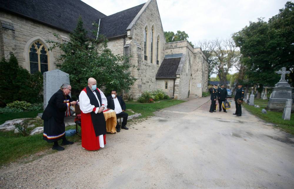 Rev. Geoffrey Woodcroft, Bishop of Rupert’s Land, smudges with Elder Amanda Wallin before a service for the queen in Winnipeg on Monday. (Winnipeg Free Press)