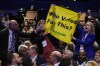 FILE - A man pulls down a banner held by two protesters as Britain's Prime Minister Liz Truss makes a speech at the Conservative Party conference at the ICC in Birmingham, England, Wednesday, Oct. 5, 2022. Truss has only been in office for six weeks. But already her libertarian economic policies have triggered a financial crisis, emergency central bank intervention, multiple U-turns and the firing of her Treasury chief. (AP Photo/Kirsty Wigglesworth, File)