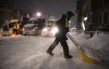 A protester shovels snow from Wellington Street in front of a blockade of trucks as a winter storm warning is in effect, on the 22nd day of a protest against COVID-19 measures that has grown into a broader anti-government protest, in Ottawa, on Friday, Feb. 18, 2022. The commission investigating the federal government's invocation of the Emergencies Act says most of the millions of dollars raised by the 